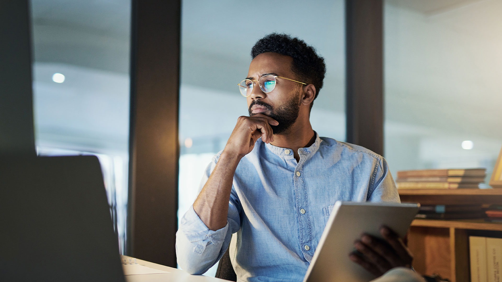 man with tablet sits in his office cabin