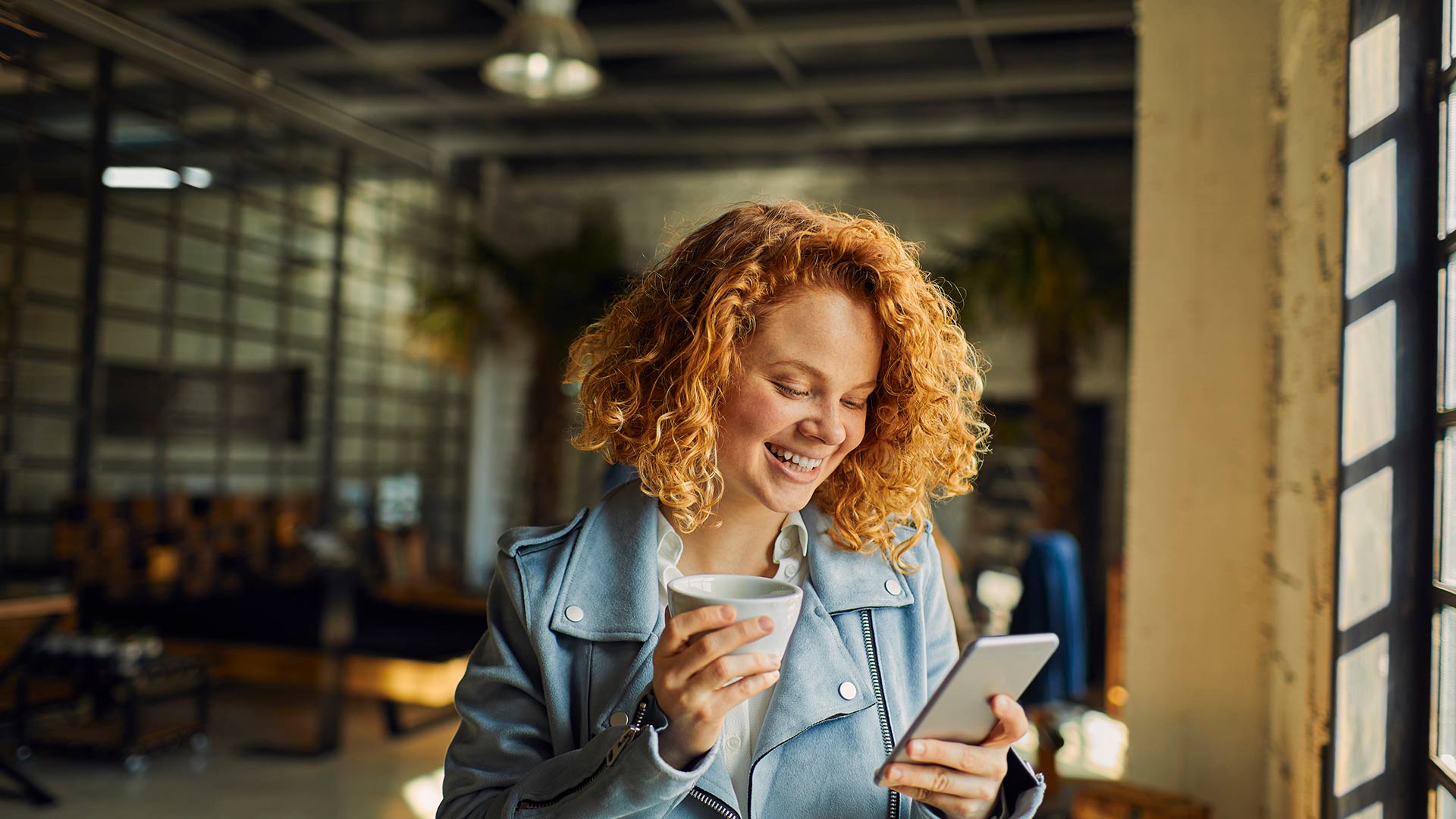 A woman smiling looking at her phone