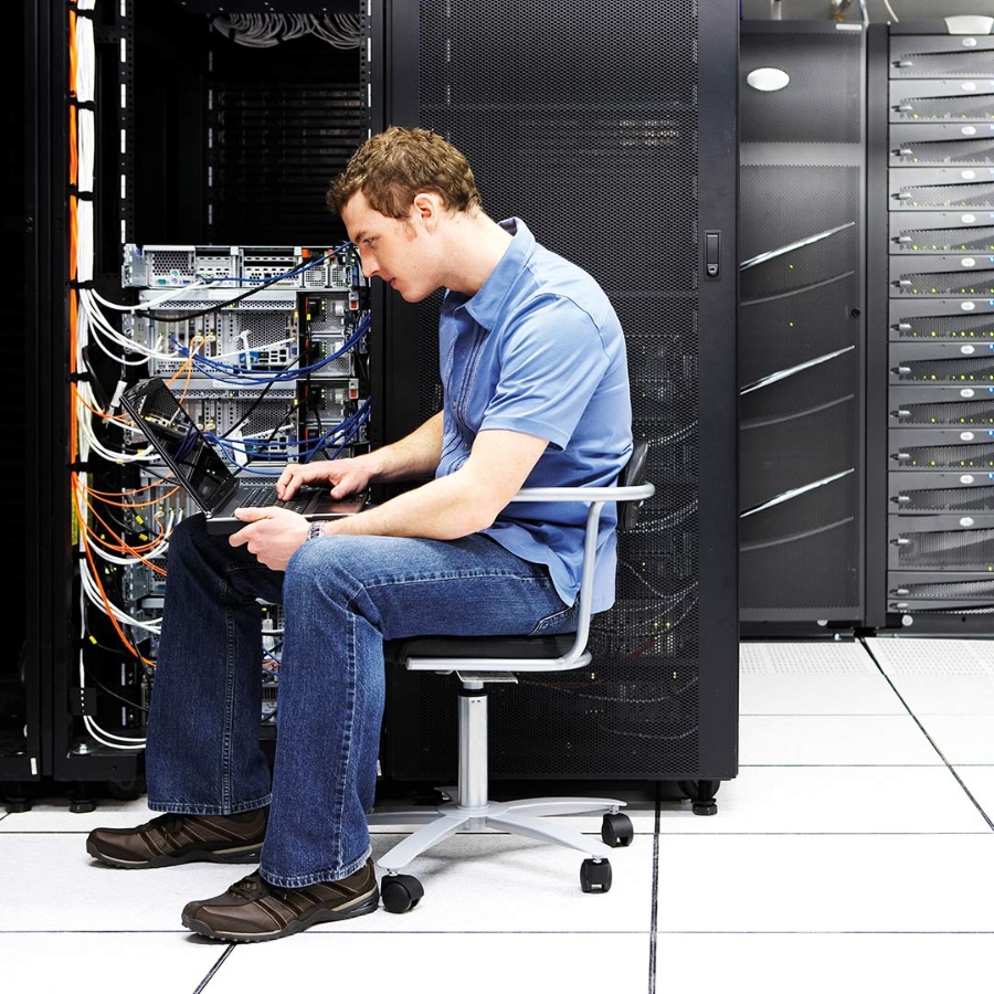 An engineer working on laptop in data center