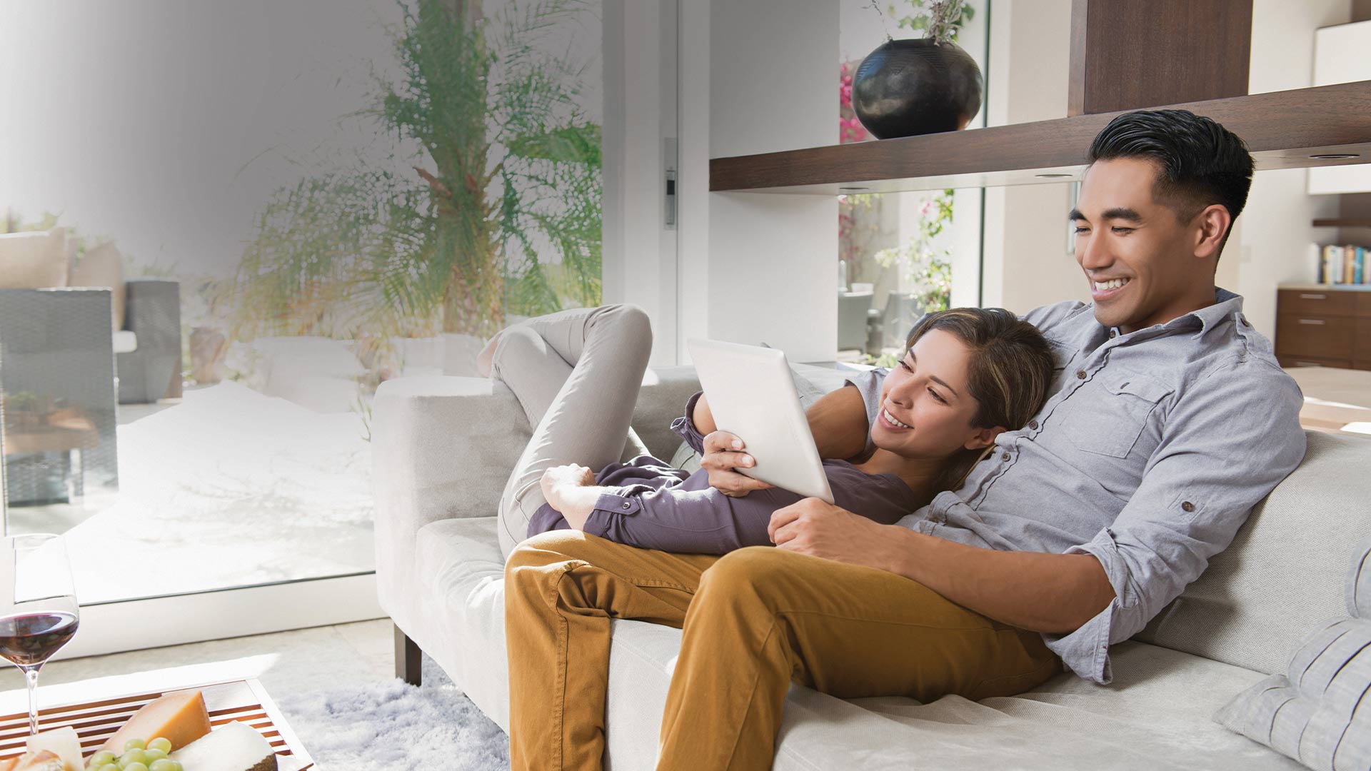 smiling Couple using tablet while relaxing in couch