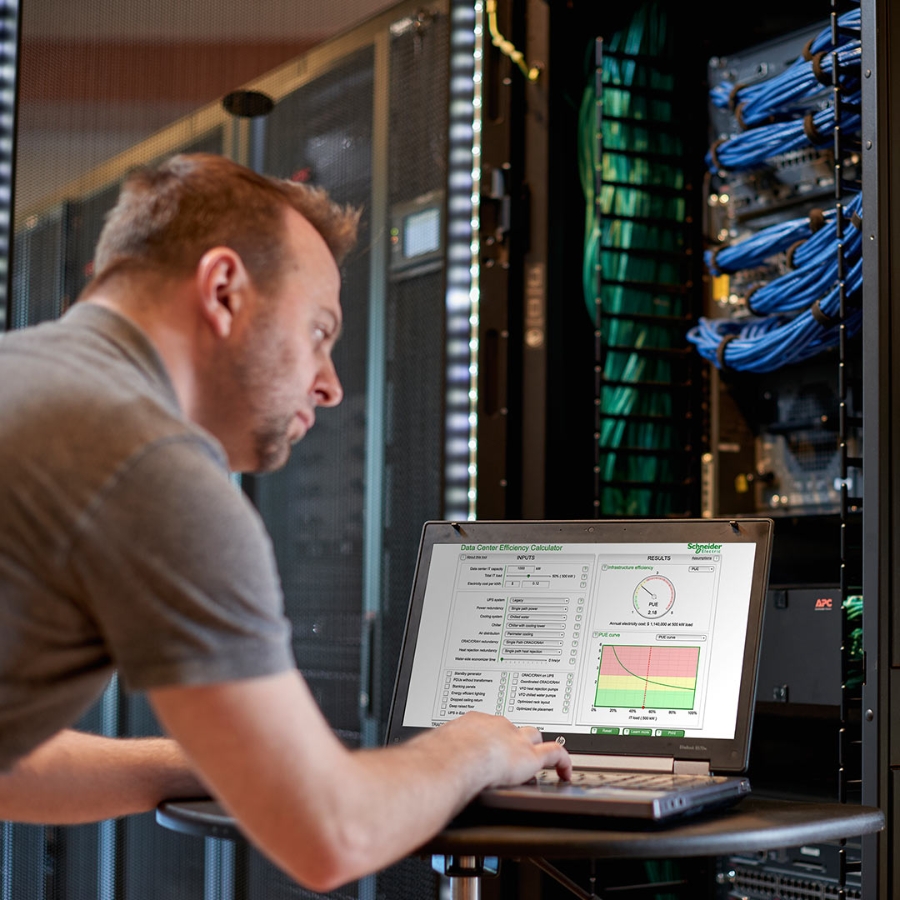 IT professional working on his laptop at a server room