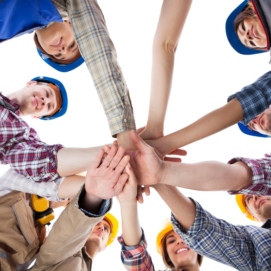 A group of young people holding their hands together in a circle formation