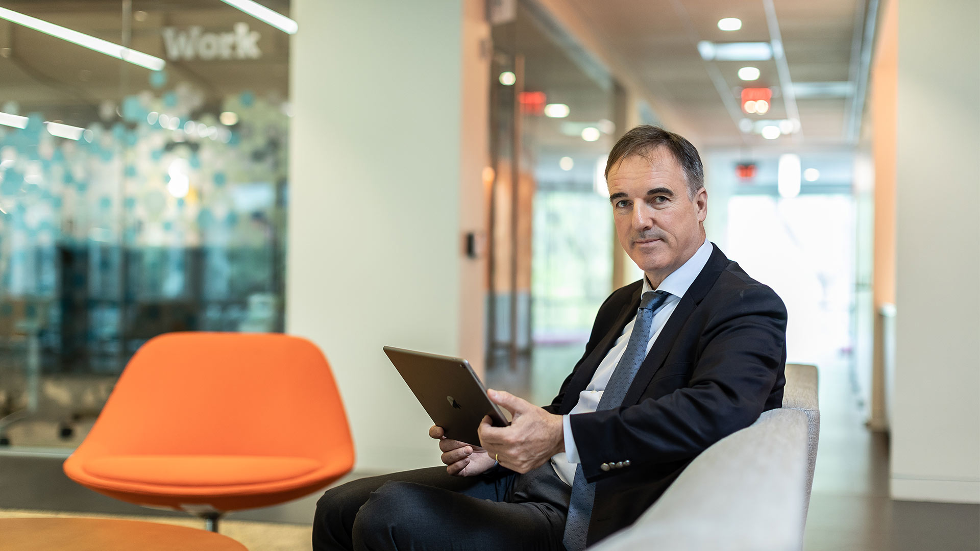 man with tablet in office corridor