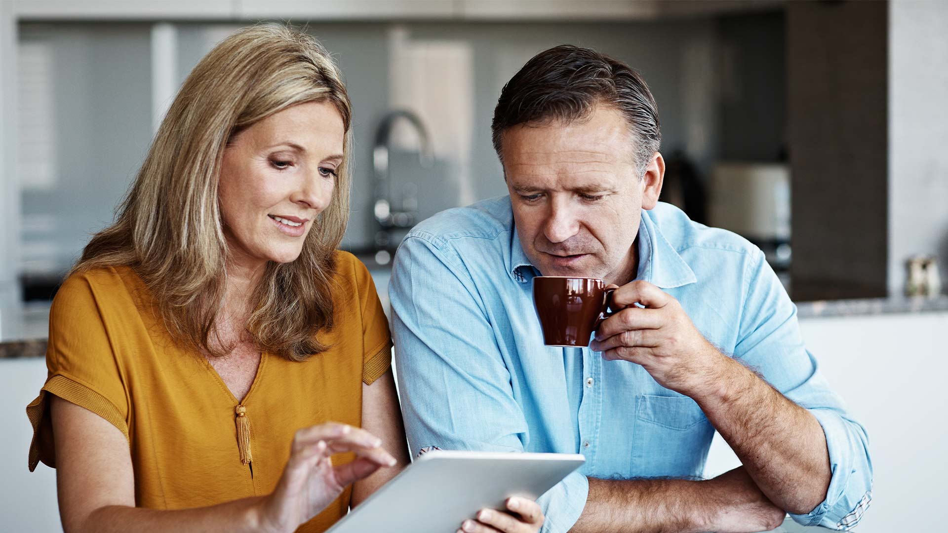 matured couple looking at tablet