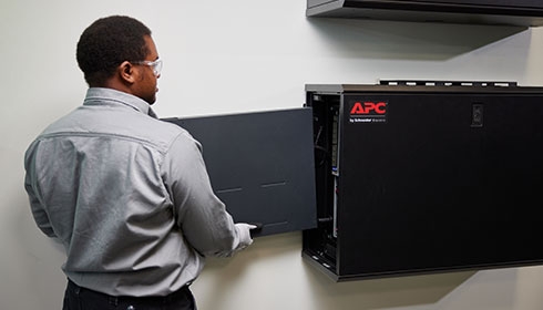 An employee installing a UPS into a APC 6U wall mounted Micro Data center