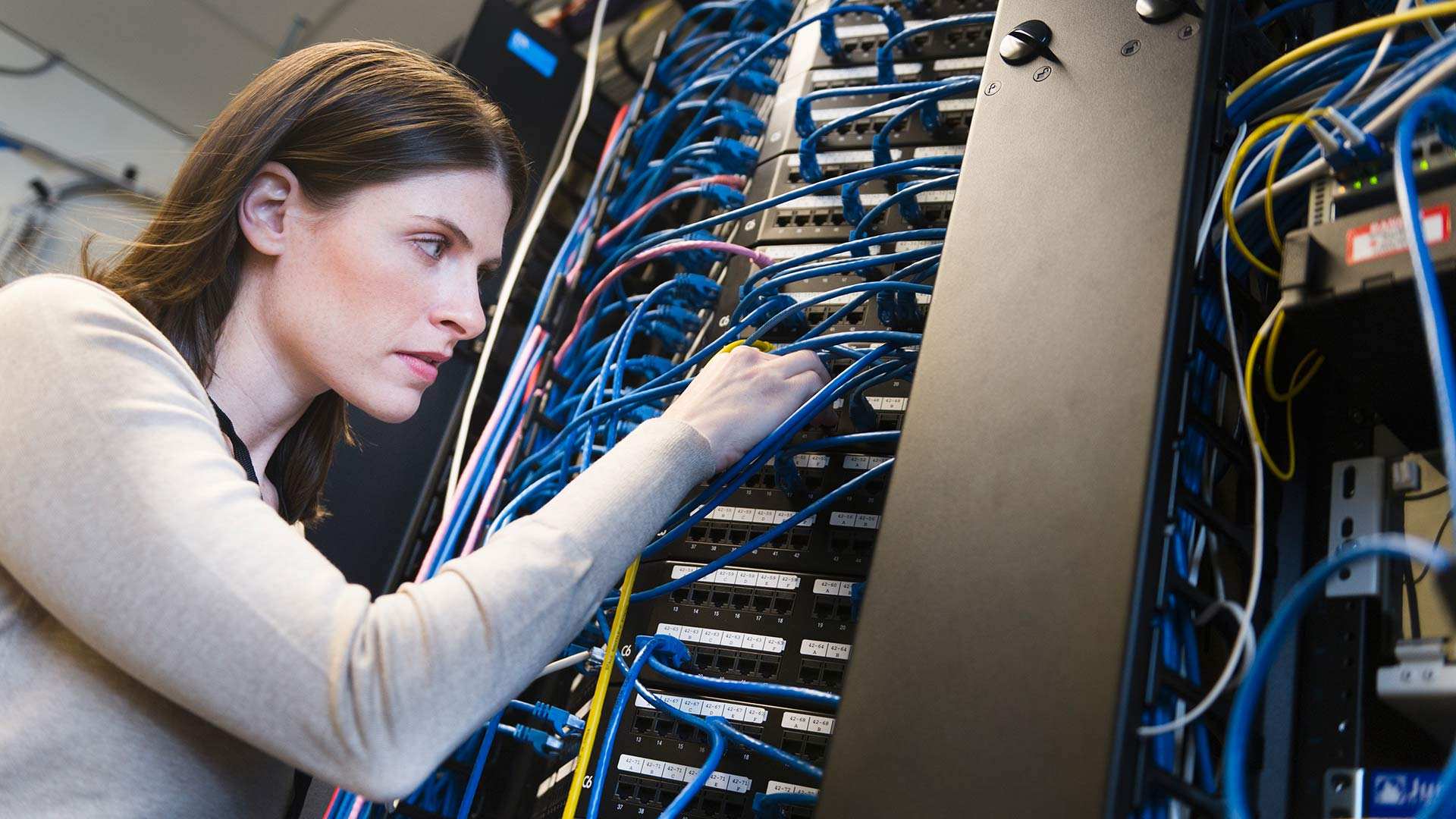 A woman fixing wires in Electric room