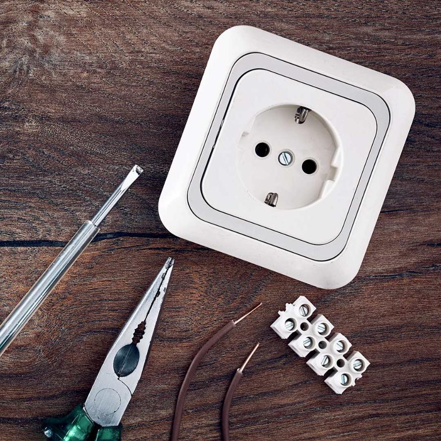 Man in suit holding an outlet and plug disguised with green felt to give the green look