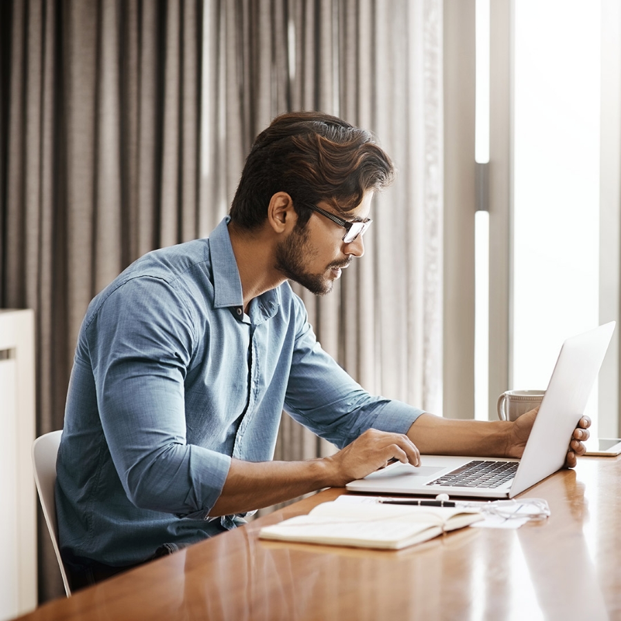 A person using laptop having coffee and snacks