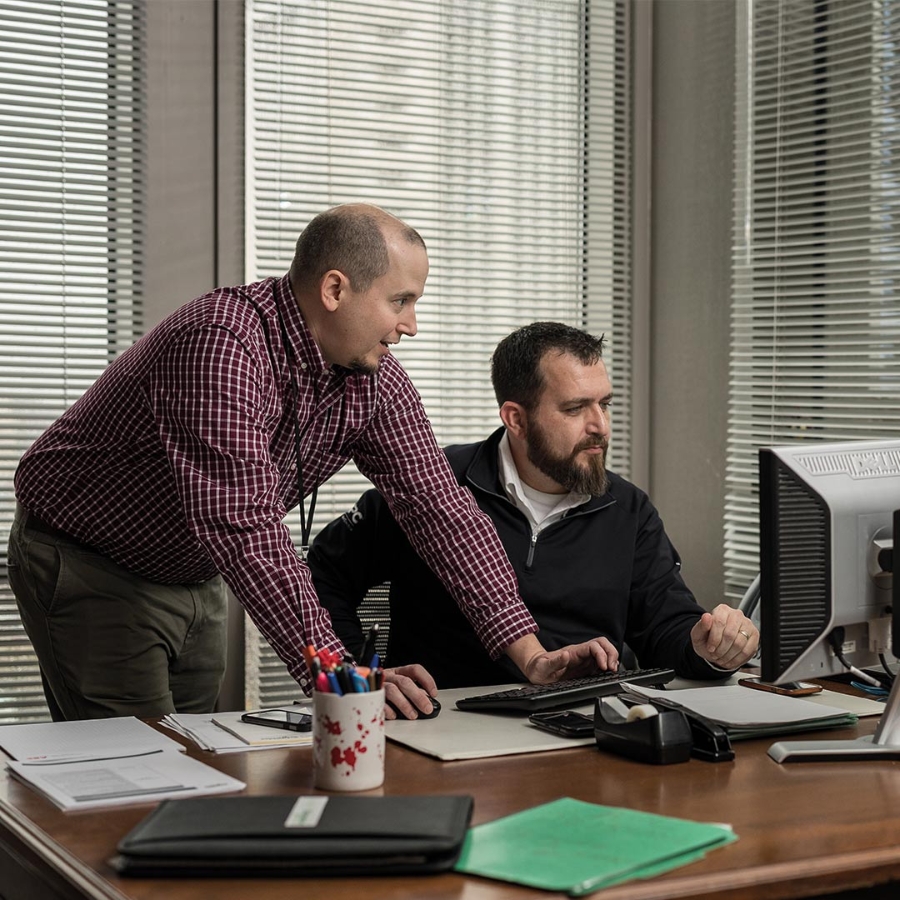 Two male business professionals working in front of the computer