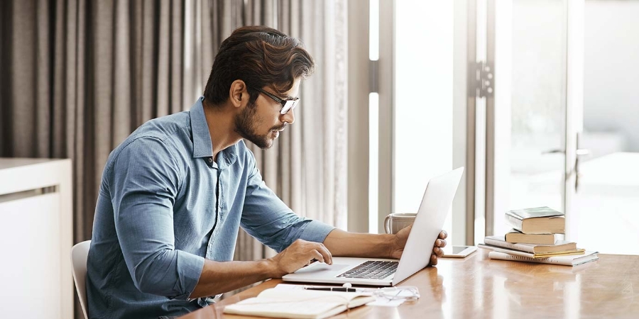 Young businessman working on his laptop in the office at home