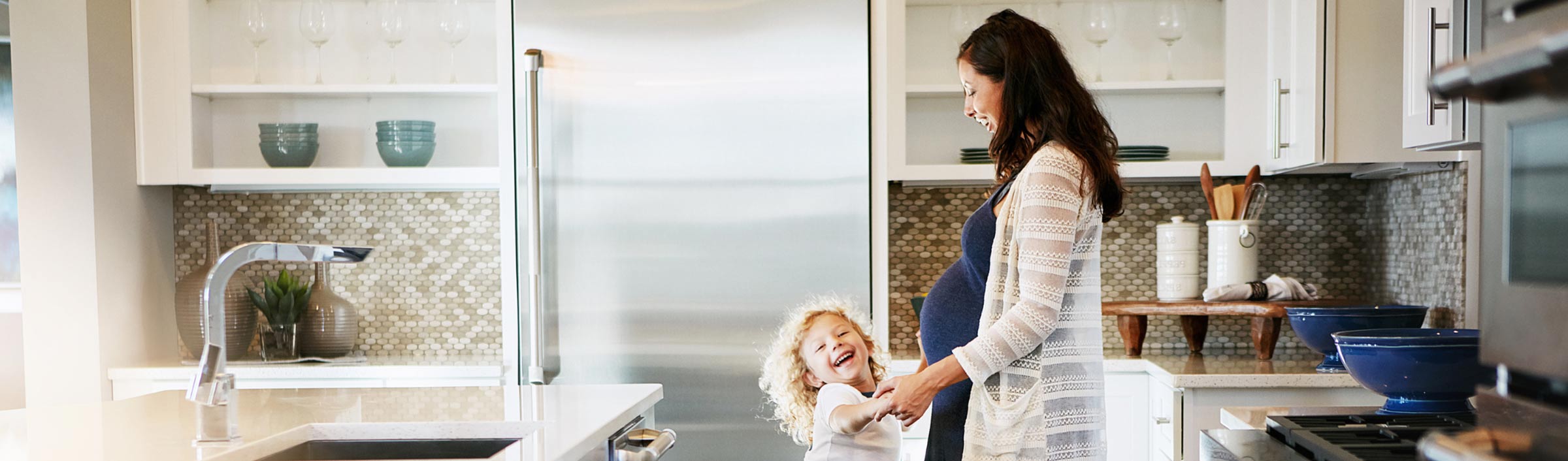 Shot of a pregnant woman bonding with her little son at home